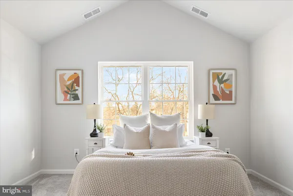 a large bed sitting in a bedroom next to a window