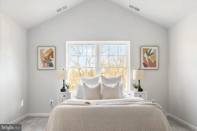 a large bed sitting in a bedroom next to a window