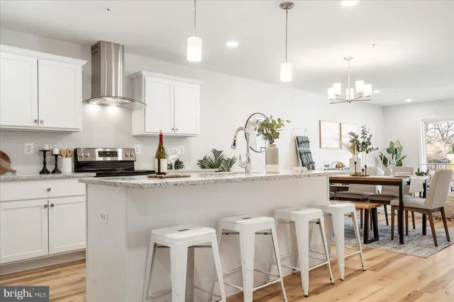 a kitchen with white cabinets and chairs