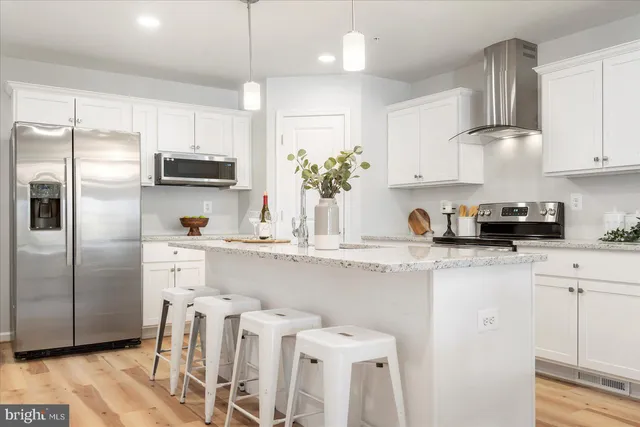 a kitchen with stainless steel appliances a sink a stove a refrigerator and cabinets