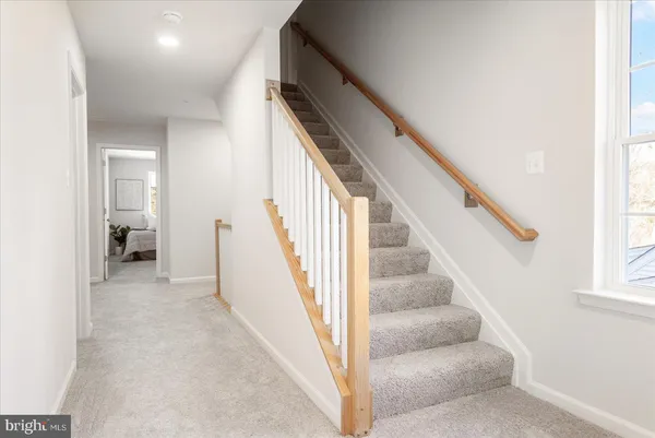 a view of staircase with white walls and a window