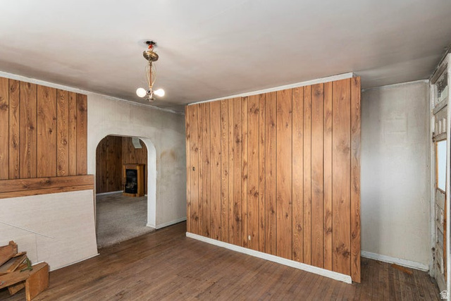 482 West 100 N Street Beaver, UT 84713 - Photo 21 of 41 Unfurnished area with wood walls, dark wood-style floors, arched walkways, and hanging lights