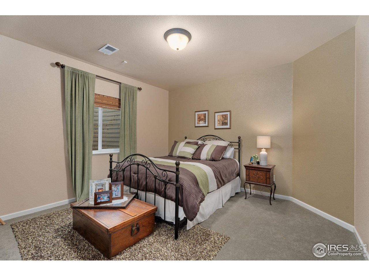 6511 Half Moon Bay Drive Windsor, CO 80550 - Photo 16 of 31 a bedroom with a bed and a night stand