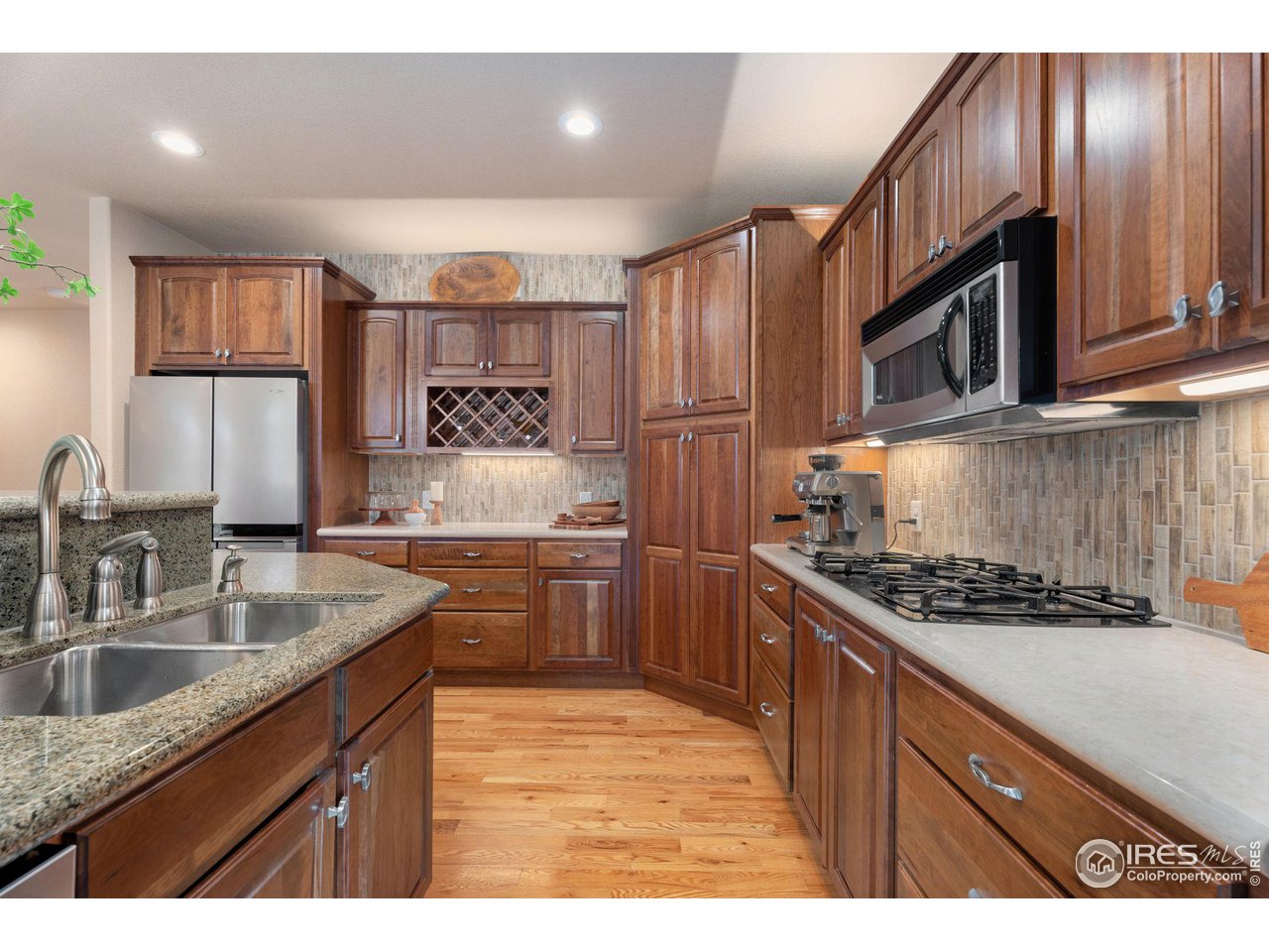 6511 Half Moon Bay Drive Windsor, CO 80550 - Photo 7 of 31 a kitchen with granite countertop stainless steel appliances a sink stove top oven and cabinets