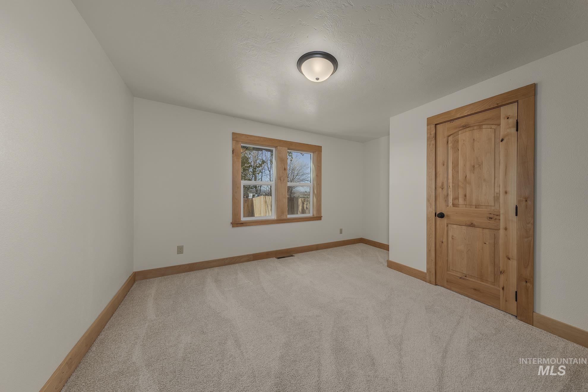 327 Macomb Road Weiser, ID 83672 - Photo 16 of 49 Unfurnished bedroom featuring carpet and a textured ceiling