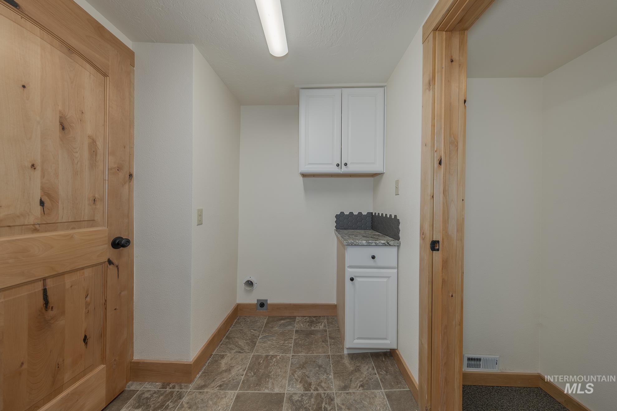 327 Macomb Road Weiser, ID 83672 - Photo 24 of 49 Laundry room with baseboards and cabinet space