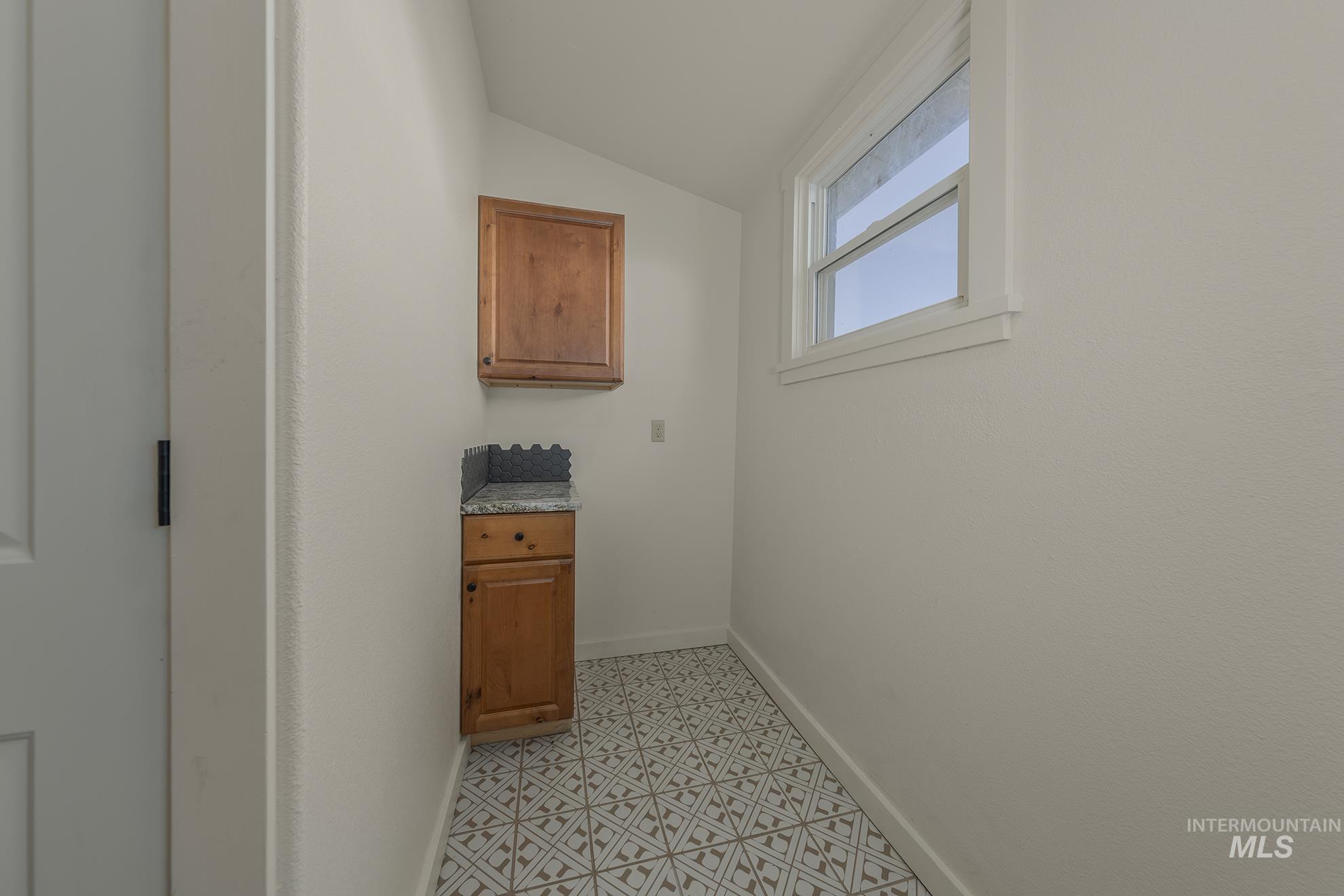 327 Macomb Road Weiser, ID 83672 - Photo 25 of 49 Laundry area with vaulted ceiling and baseboards