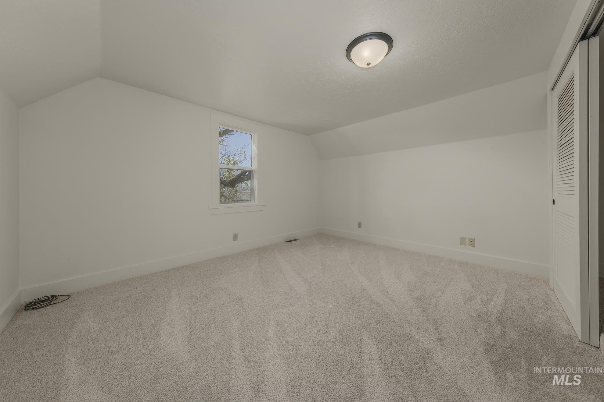 327 Macomb Road Weiser, ID 83672 - Photo 26 of 49 Additional living space with lofted ceiling and carpet floors