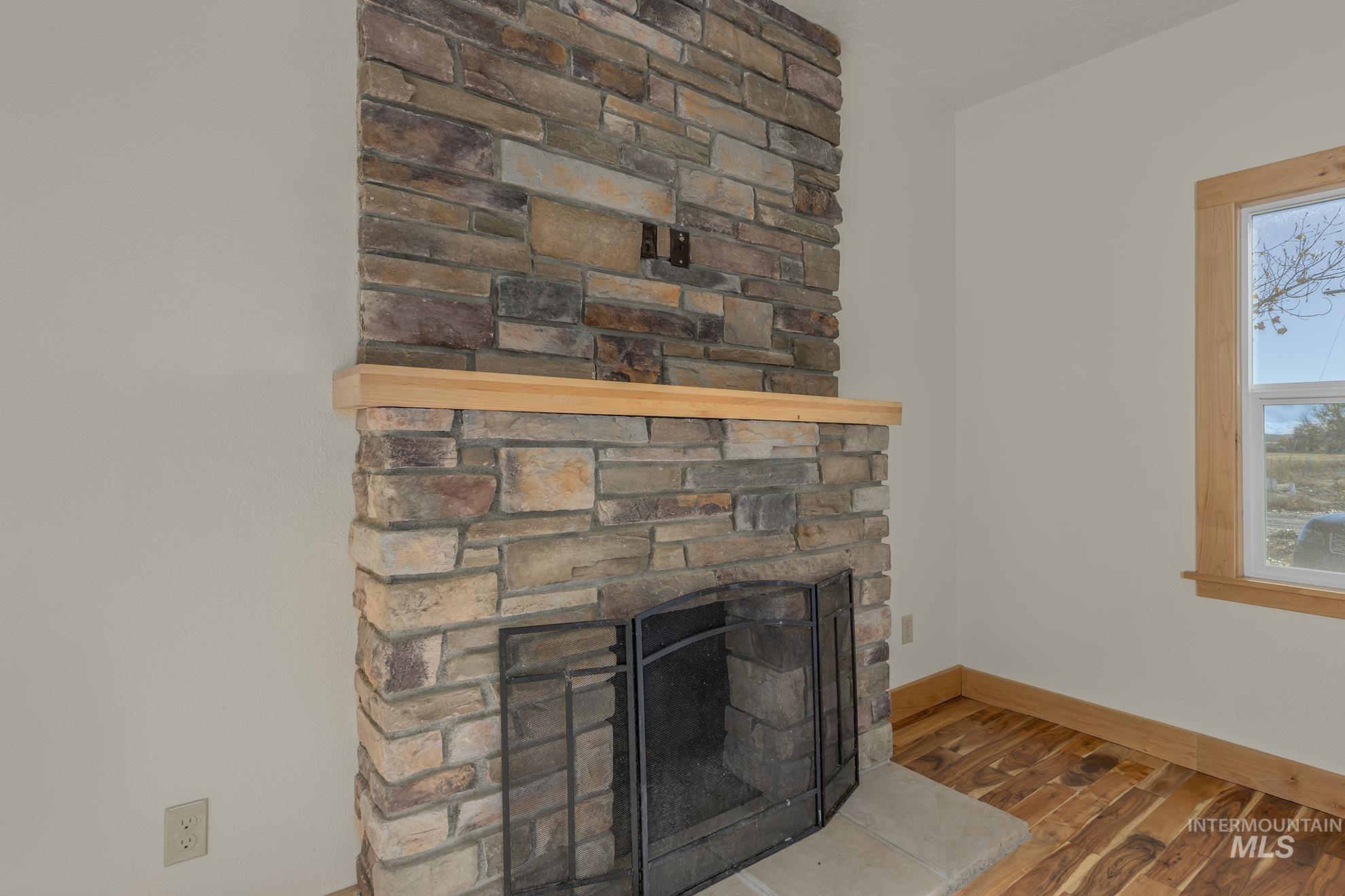 327 Macomb Road Weiser, ID 83672 - Photo 8 of 49 Detailed view of wood finished floors and a stone fireplace