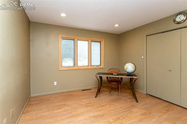 a view of empty room with wooden floor