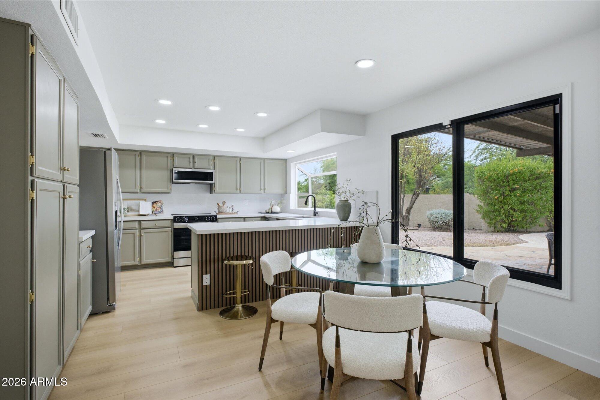 405 East Marny Road Tempe, AZ 85288 - Photo 13 of 36 a kitchen with a table chairs refrigerator and cabinets