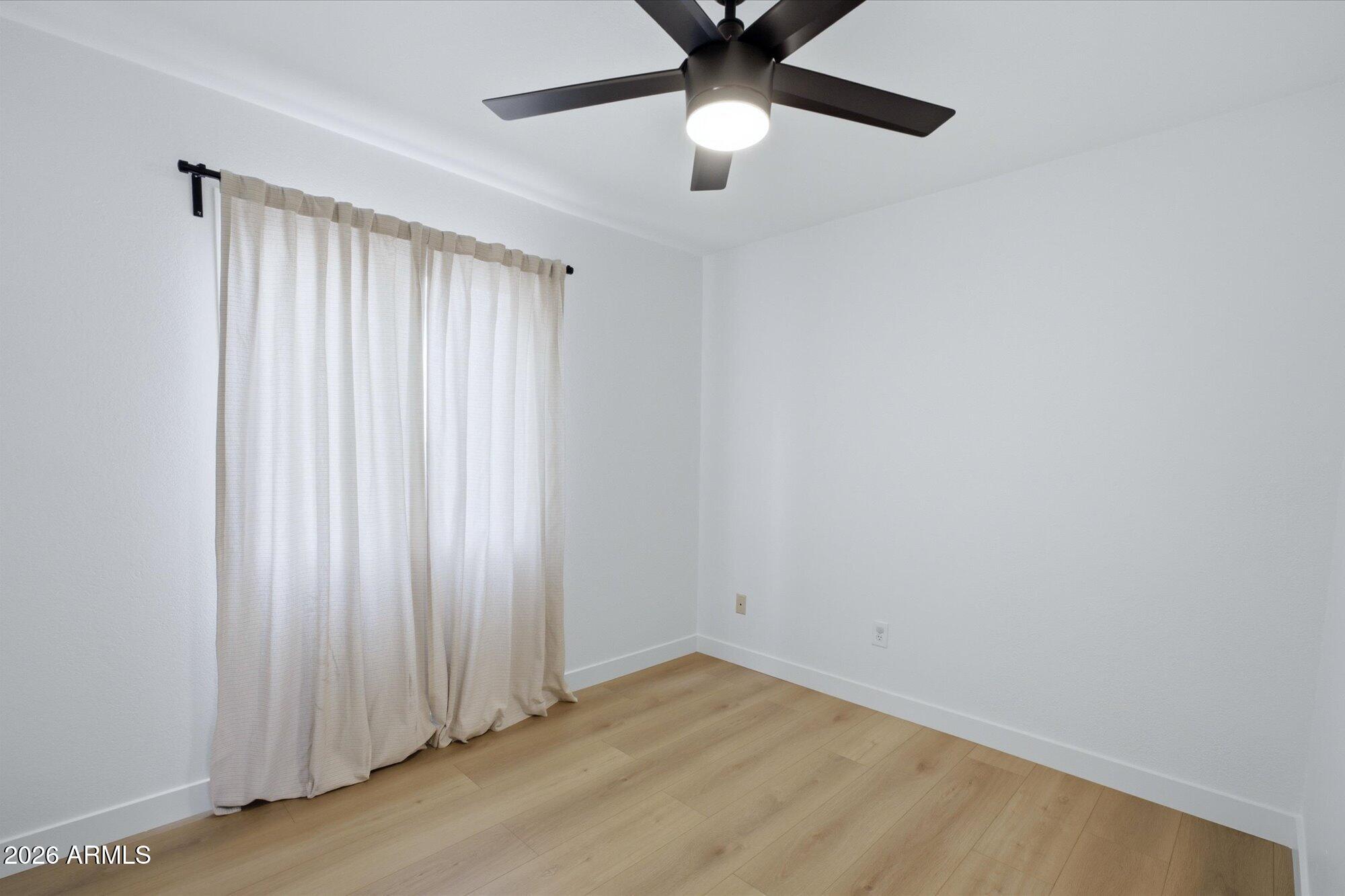 405 East Marny Road Tempe, AZ 85288 - Photo 26 of 36 an empty room with a window and a chandelier fan