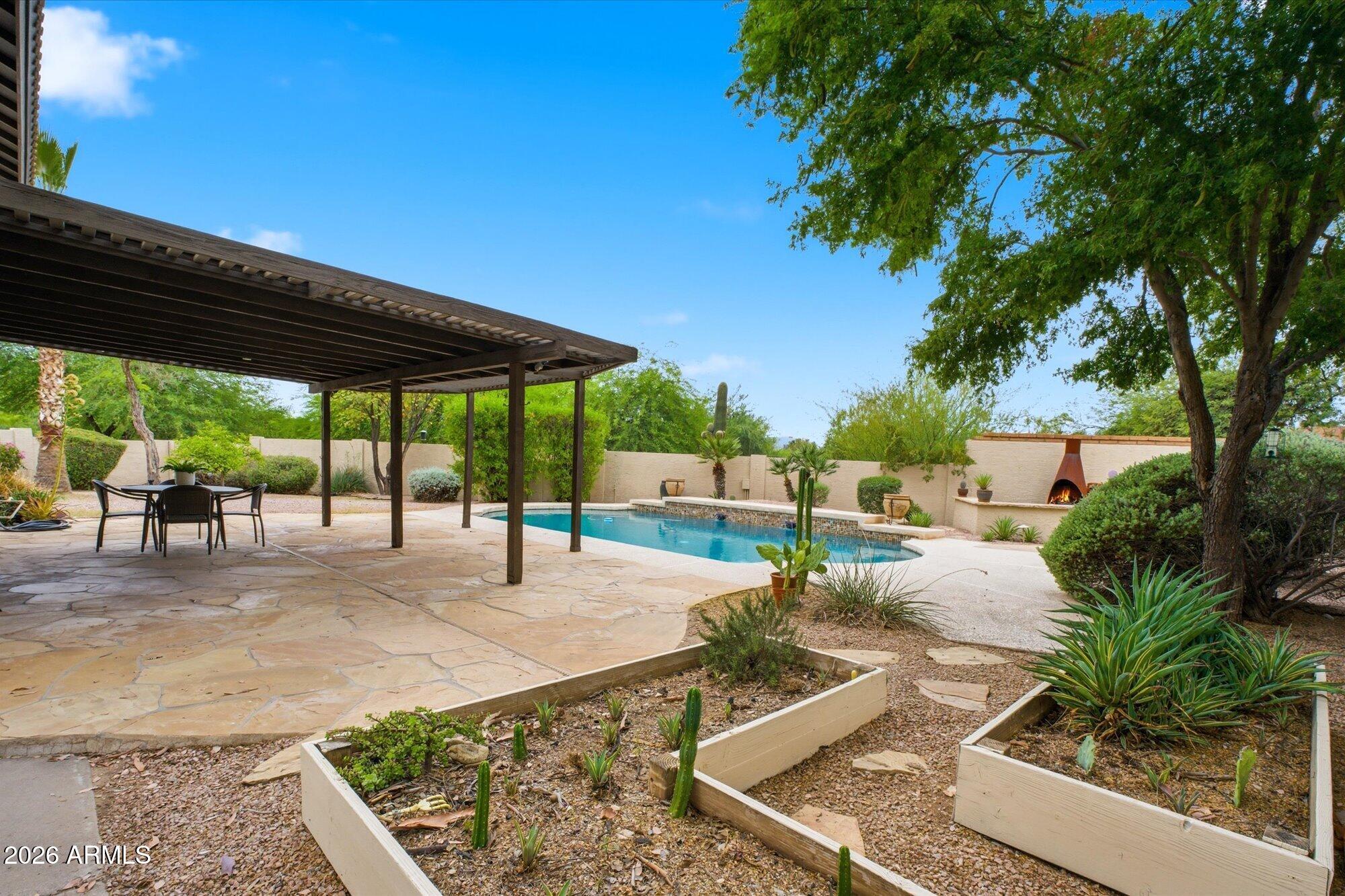 405 East Marny Road Tempe, AZ 85288 - Photo 27 of 36 a view of a patio with a table and chairs under an umbrella with a barbeque