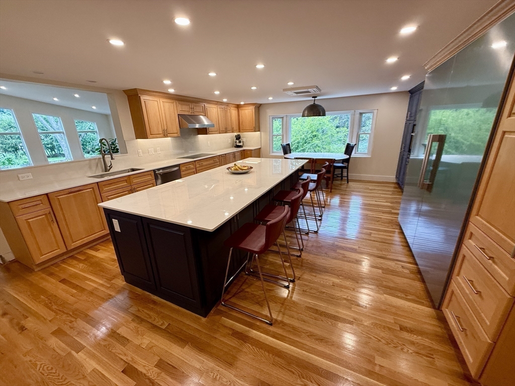 1 Maureen Road Lexington, MA 02420 - Photo 6 of 20 a kitchen with stainless steel appliances kitchen island granite countertop a table chairs and a wooden floors