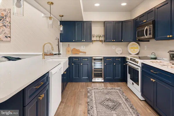 a kitchen with stainless steel appliances granite countertop a sink stove a refrigerator and cabinets with wooden floor