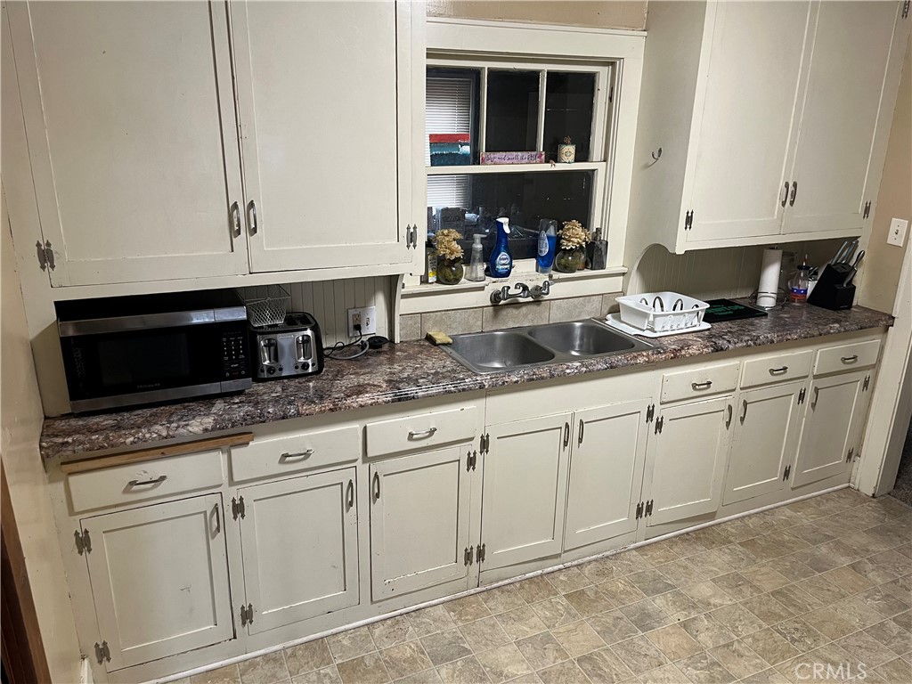 617 Orient Street Chico, CA 95928 - Photo 2 of 8 a kitchen with granite countertop white cabinets and white appliances