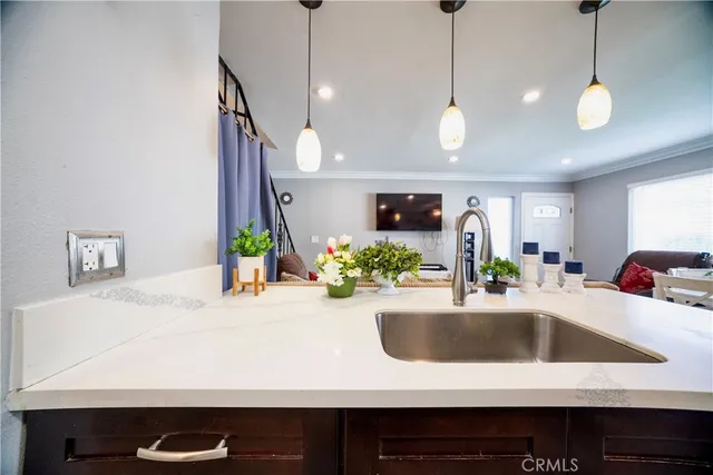 a large kitchen with kitchen island a counter space a sink and living room view