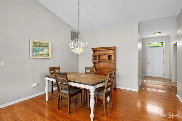 a view of a dining room with furniture wooden floor and a chandelier