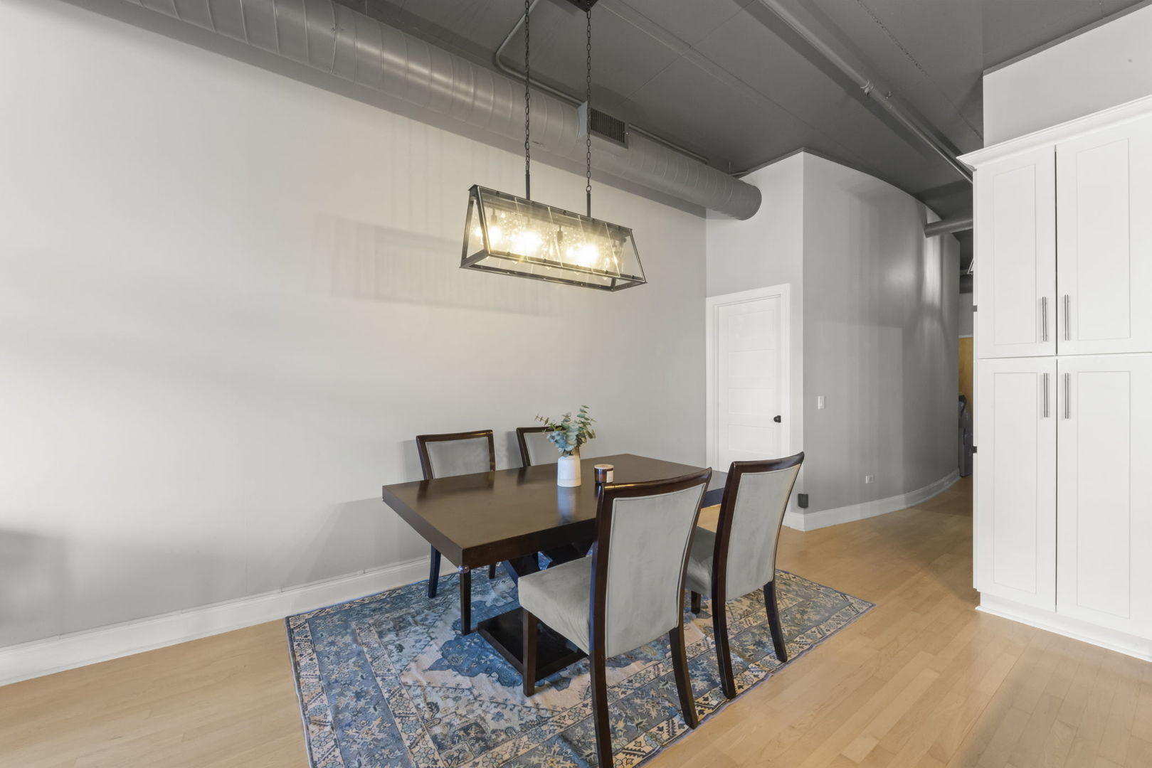 1301 West Madison Street, Unit 305 Chicago, IL 60607 - Photo 8 of 22 a view of a dining room with furniture and chandelier