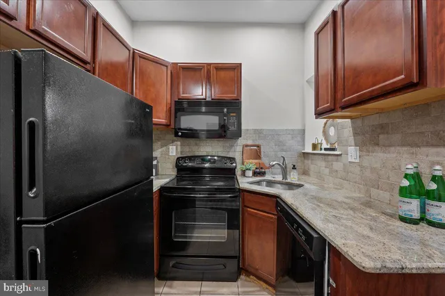 a kitchen with stainless steel appliances granite countertop a stove a refrigerator and a sink