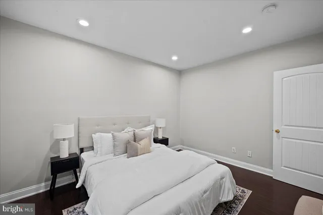 a bedroom with a bed and a lamp with the wooden floor