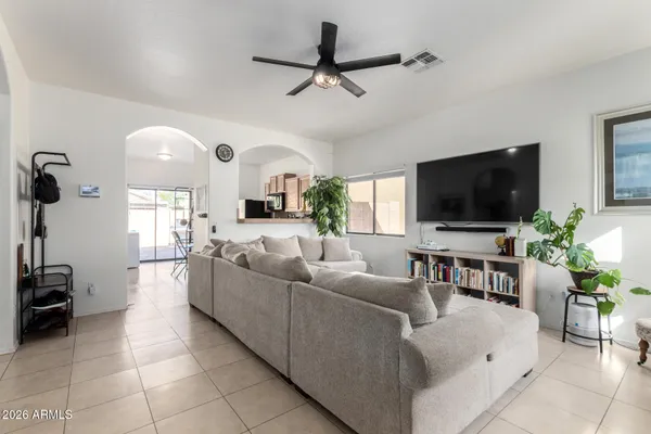 a living room with furniture a flat screen tv and a window