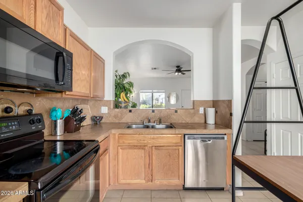 a kitchen with stainless steel appliances granite countertop a sink a stove a microwave a refrigerator and cabinets