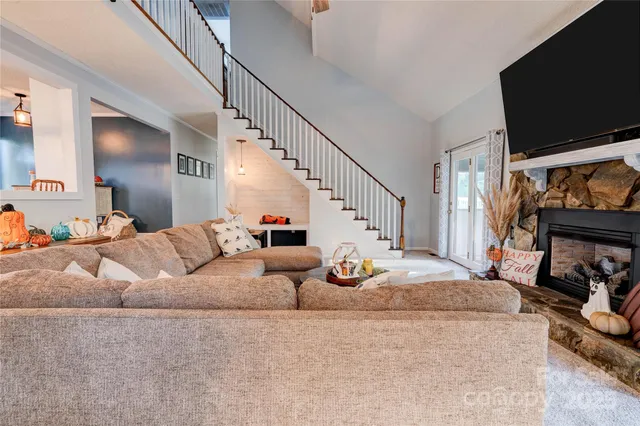 a living room with couches chairs and kitchen view