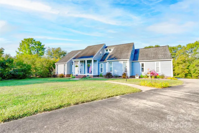 a view of a big house with a big yard and large trees