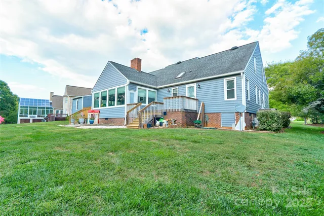 a view of swimming pool with seating space and trees in the background