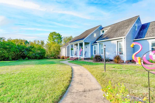 a view of a house with a yard and porch