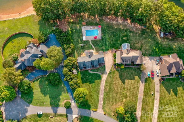 an aerial view of a house with a yard and lake view