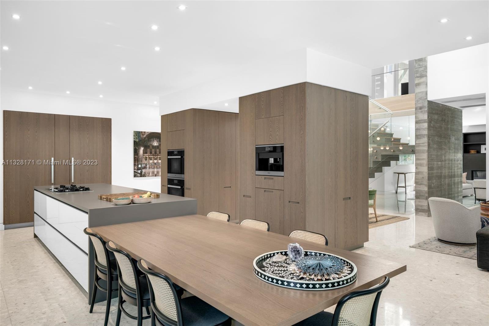 390 Pacific Road Key Biscayne, FL 33149 - Photo 9 of 37 a kitchen with stainless steel appliances granite countertop a table and chairs