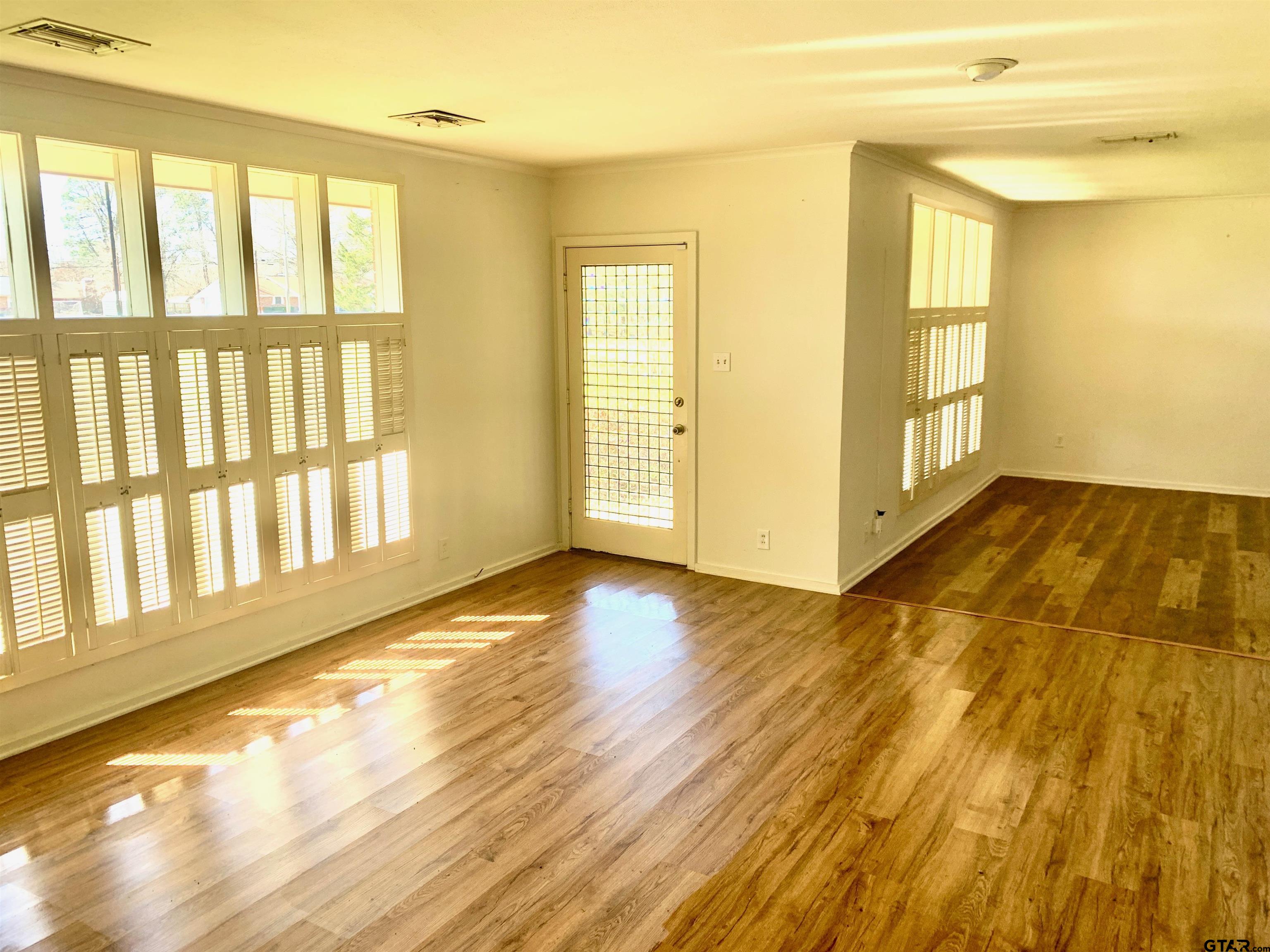 829 East Goode Street Quitman, TX 75783 - Photo 9 of 20 a view of an empty room with wooden floor and a window
