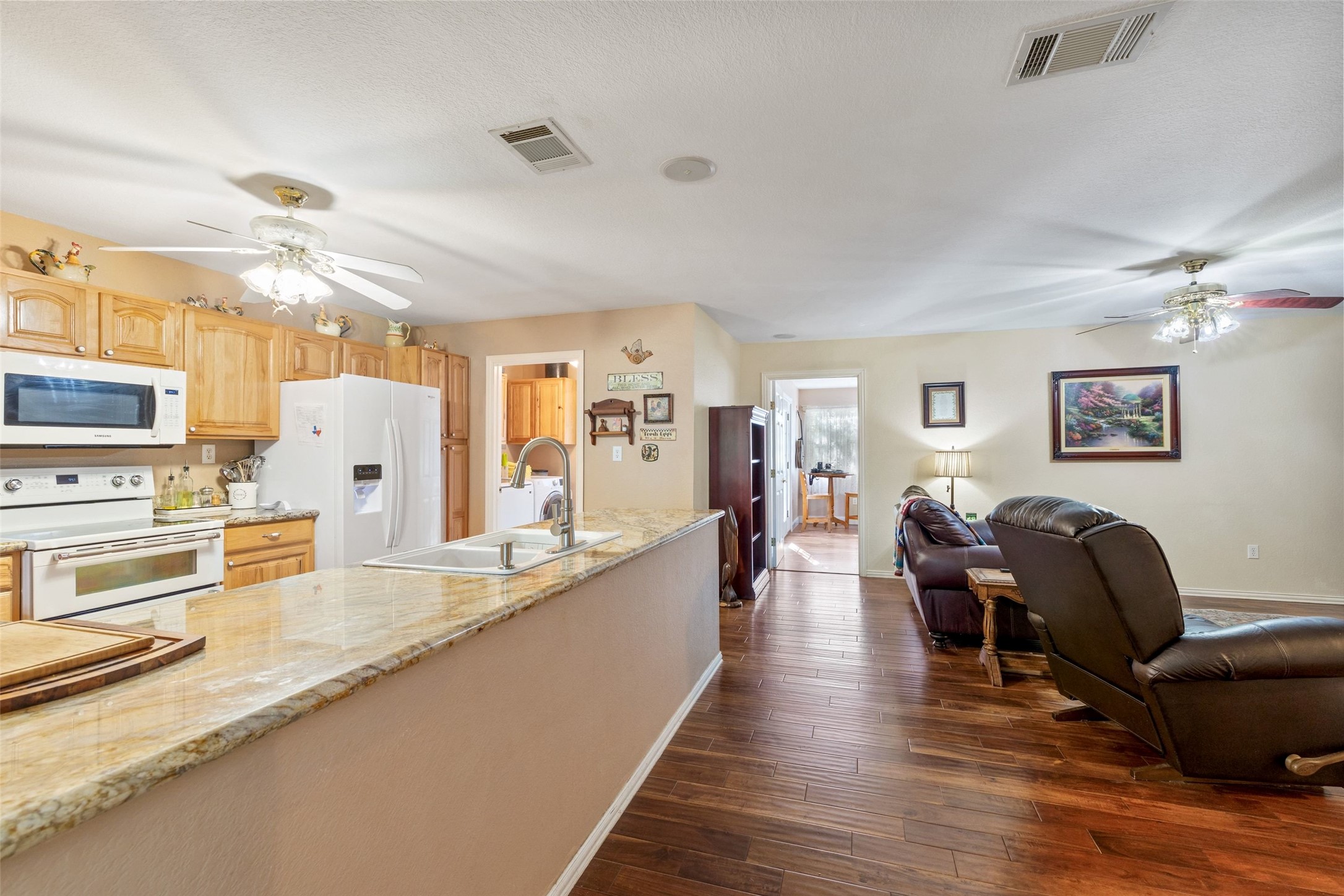 399 Upper Elgin River Road Elgin, TX 78621 - Photo 24 of 39 Kitchen featuring ceiling fan, light wood finish cabinets, white appliances, and dark wood finished floors