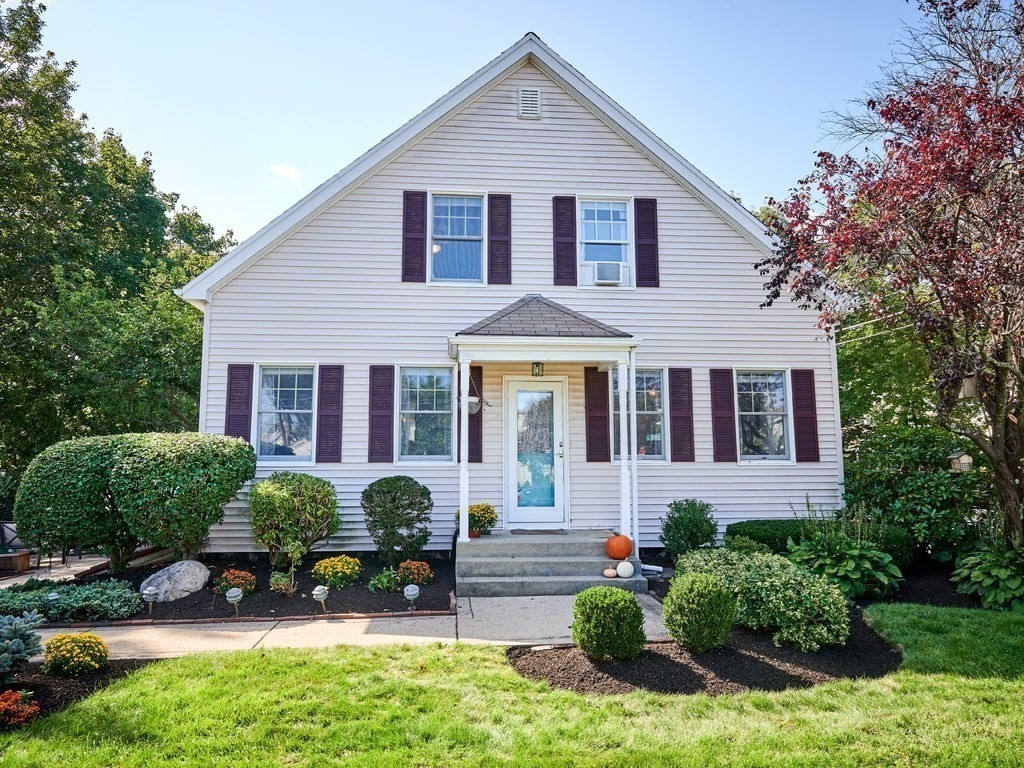 a front view of a house with a yard and potted plants