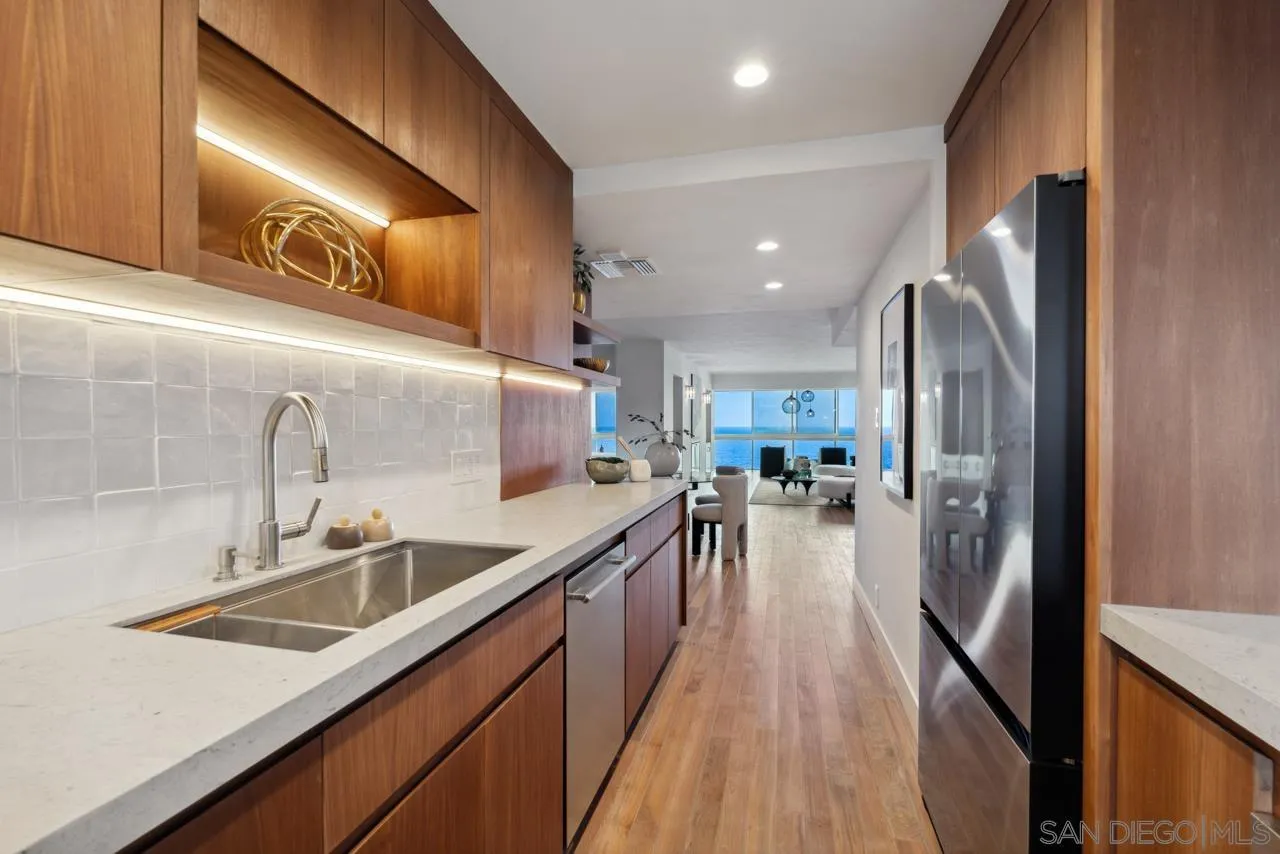 939 Coast Boulevard, Unit 12C La Jolla, CA 92037 - Photo 7 of 41 a view of a kitchen with kitchen island a large counter top space a sink stainless steel appliances and cabinets