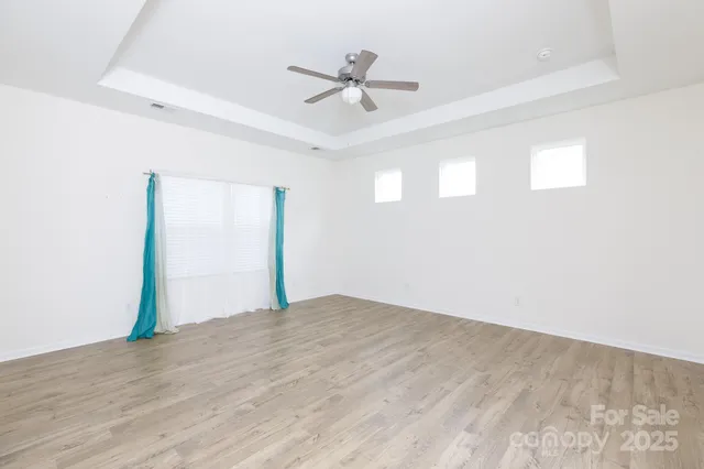 an empty room with fan and windows