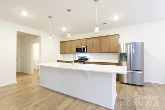 a kitchen with stainless steel appliances a refrigerator sink and microwave