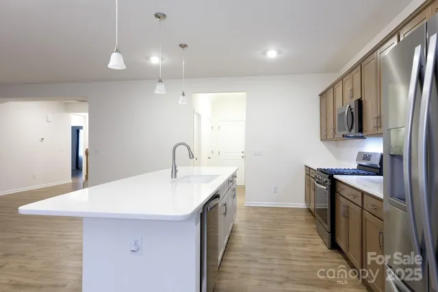 a kitchen with stainless steel appliances granite countertop a sink stove and refrigerator