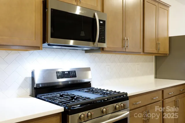 a kitchen with stainless steel appliances a stove and a microwave