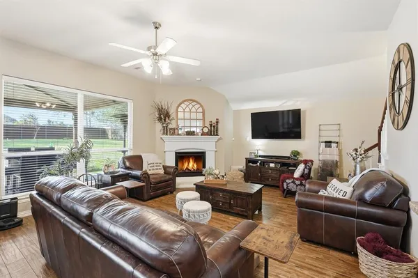 a living room with furniture a fireplace and a flat screen tv
