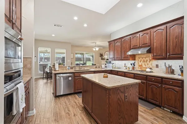 a kitchen with granite countertop wooden cabinets and a sink