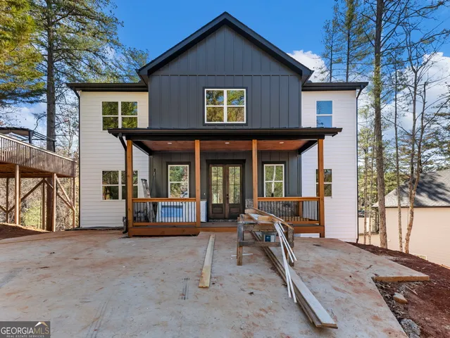 a view of a house with large windows and a small yard