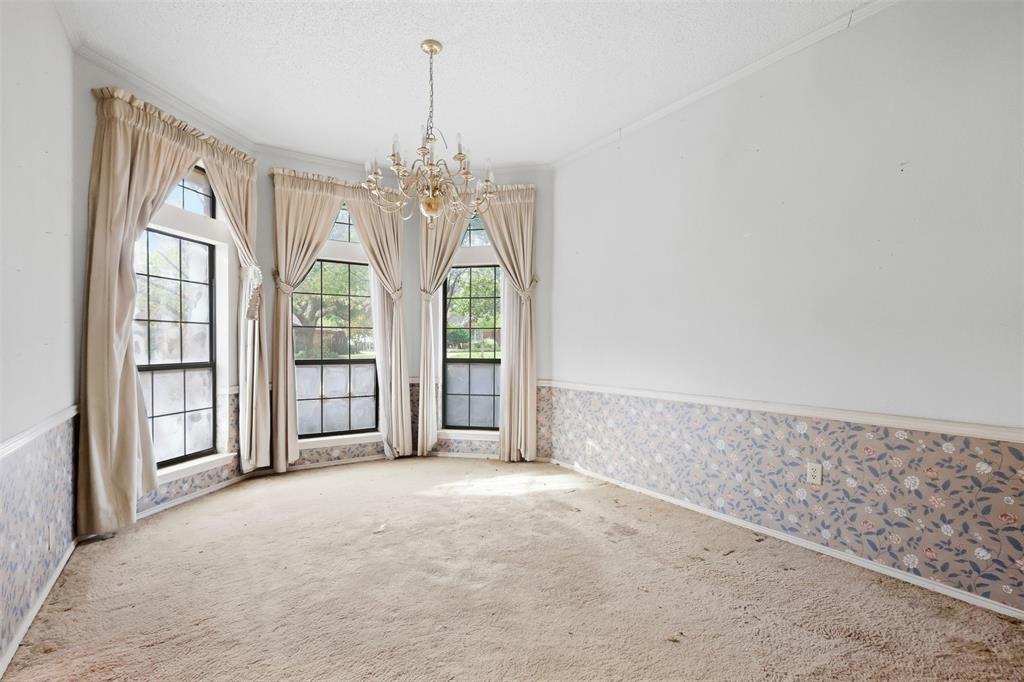 37 Timbergreen Circle Denton, TX 76205 - Photo 8 of 31 Curved bay window offering multiple panes, decorative crystal chandelier, textured ceiling, and patterned wainscoting