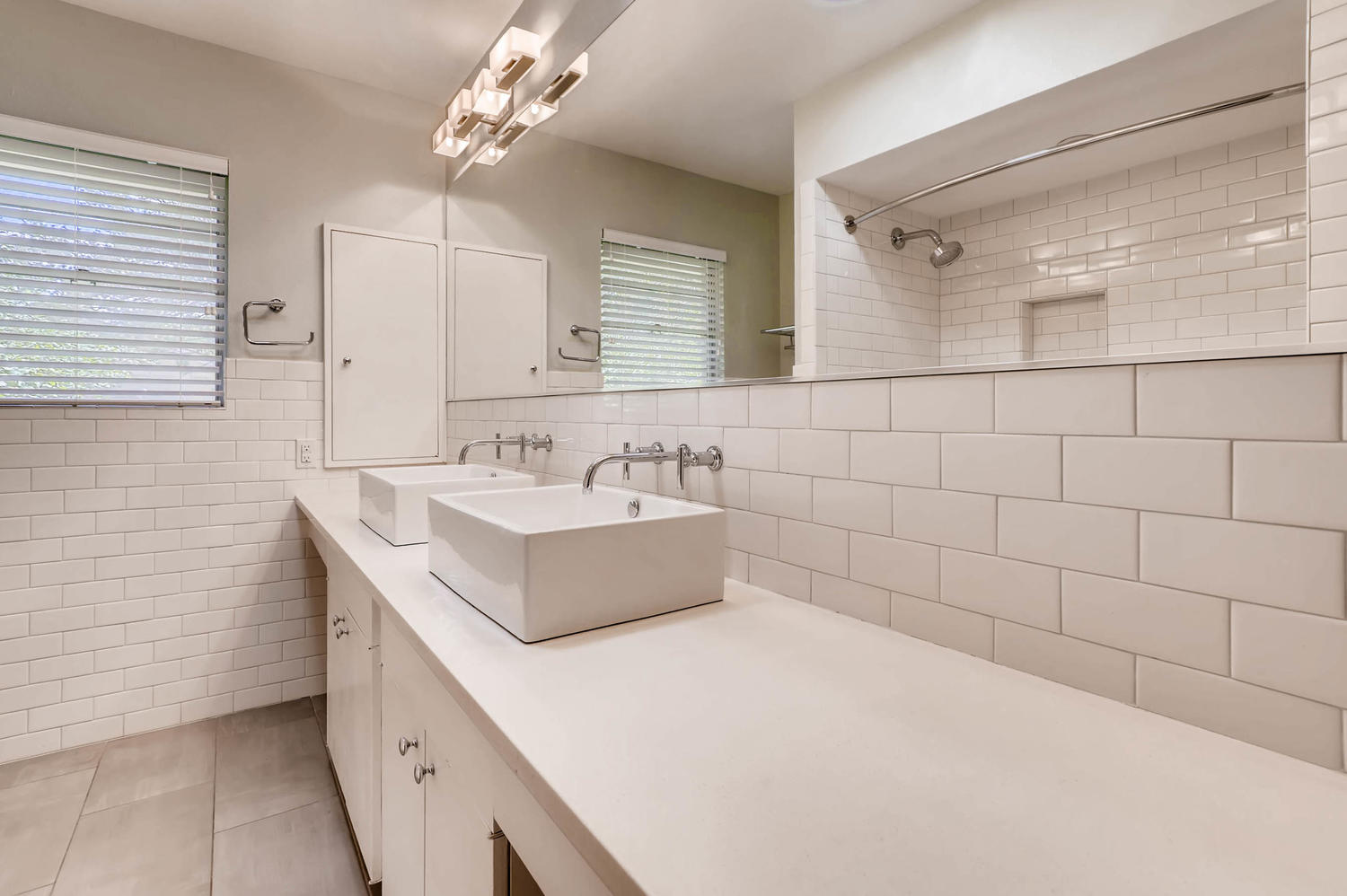 446 Pike Road San Antonio, TX 78209 - Photo 17 of 28 Dual vessel sinks and modern fixtures elevate this contemporary primary bathroom.