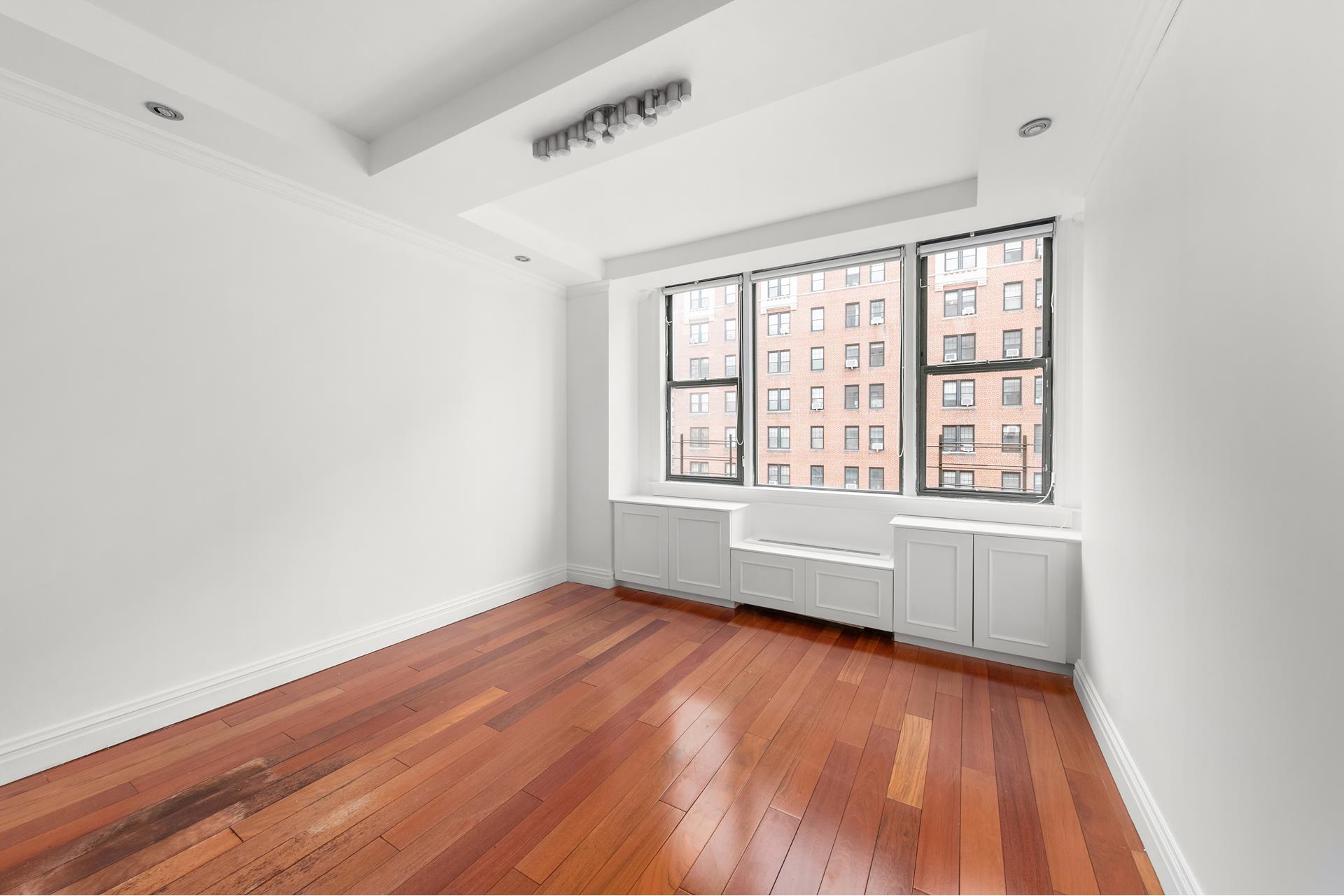 200 West 79th Street, Unit 10GH Manhattan, NY 10024 - Photo 11 of 19 an empty room with wooden floor and windows