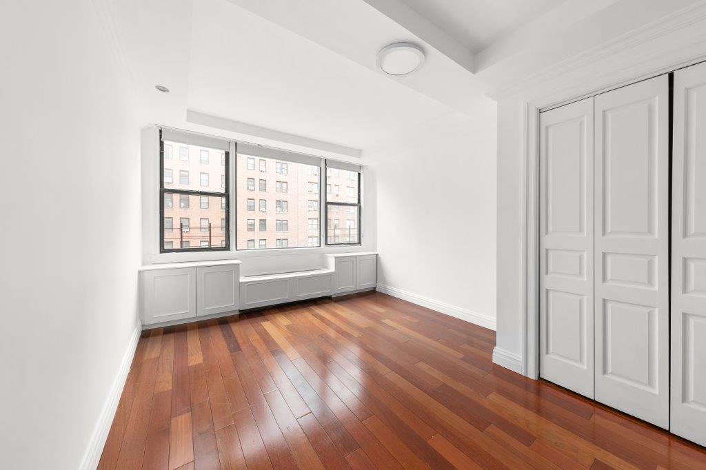 200 West 79th Street, Unit 10GH Manhattan, NY 10024 - Photo 13 of 19 an empty room with wooden floor and windows