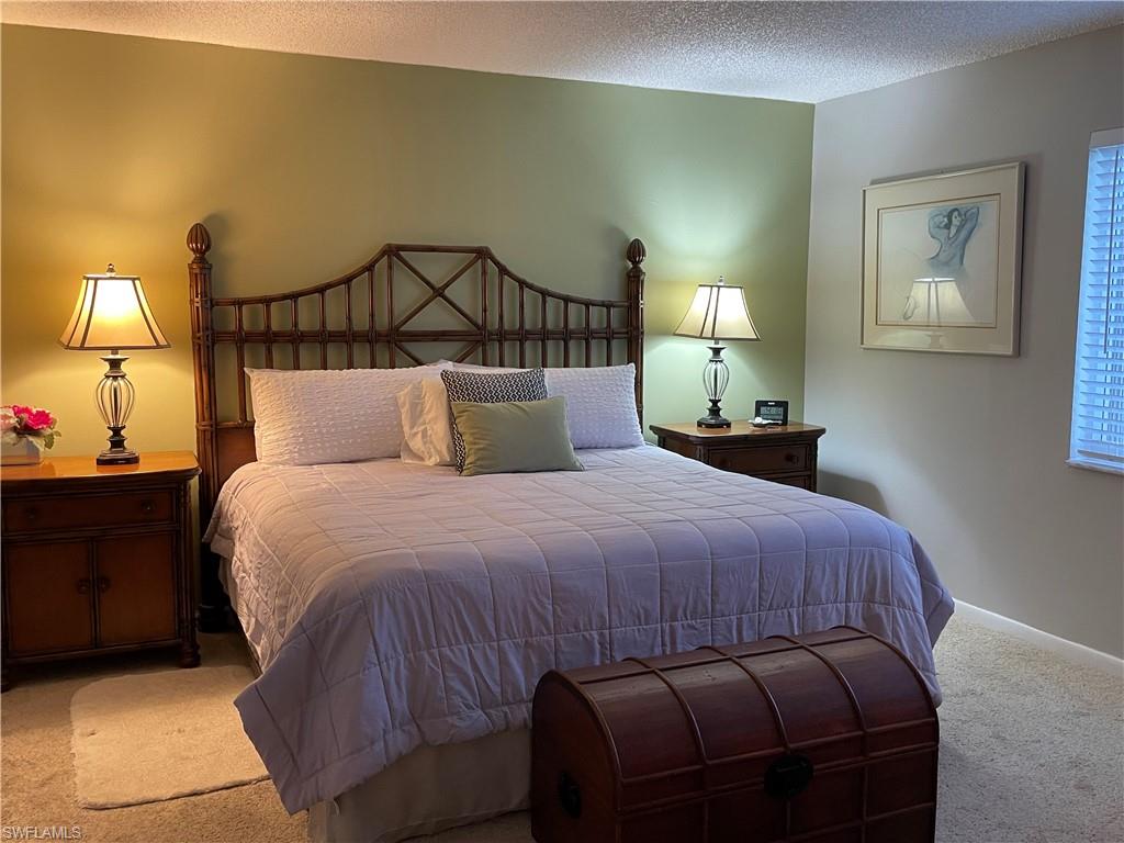 541 Teryl Road, Unit 1 Naples, FL 34112 - Photo 14 of 33 a bedroom with a bed and a lamp with the dresser