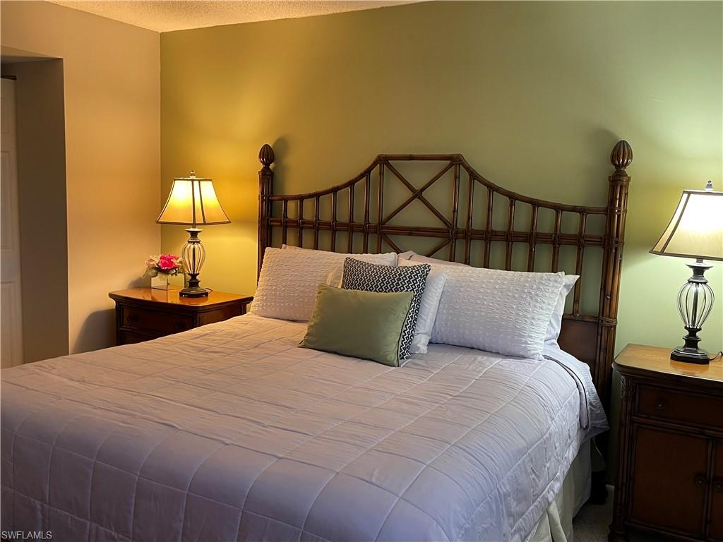 541 Teryl Road, Unit 1 Naples, FL 34112 - Photo 15 of 33 a bedroom with a bed and a lamp on table